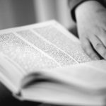 En hand som håller i en bok.