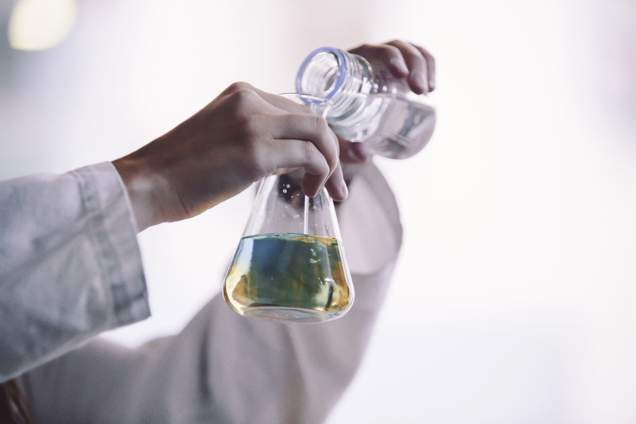 Färgad vätska hälls i en glasbägare.