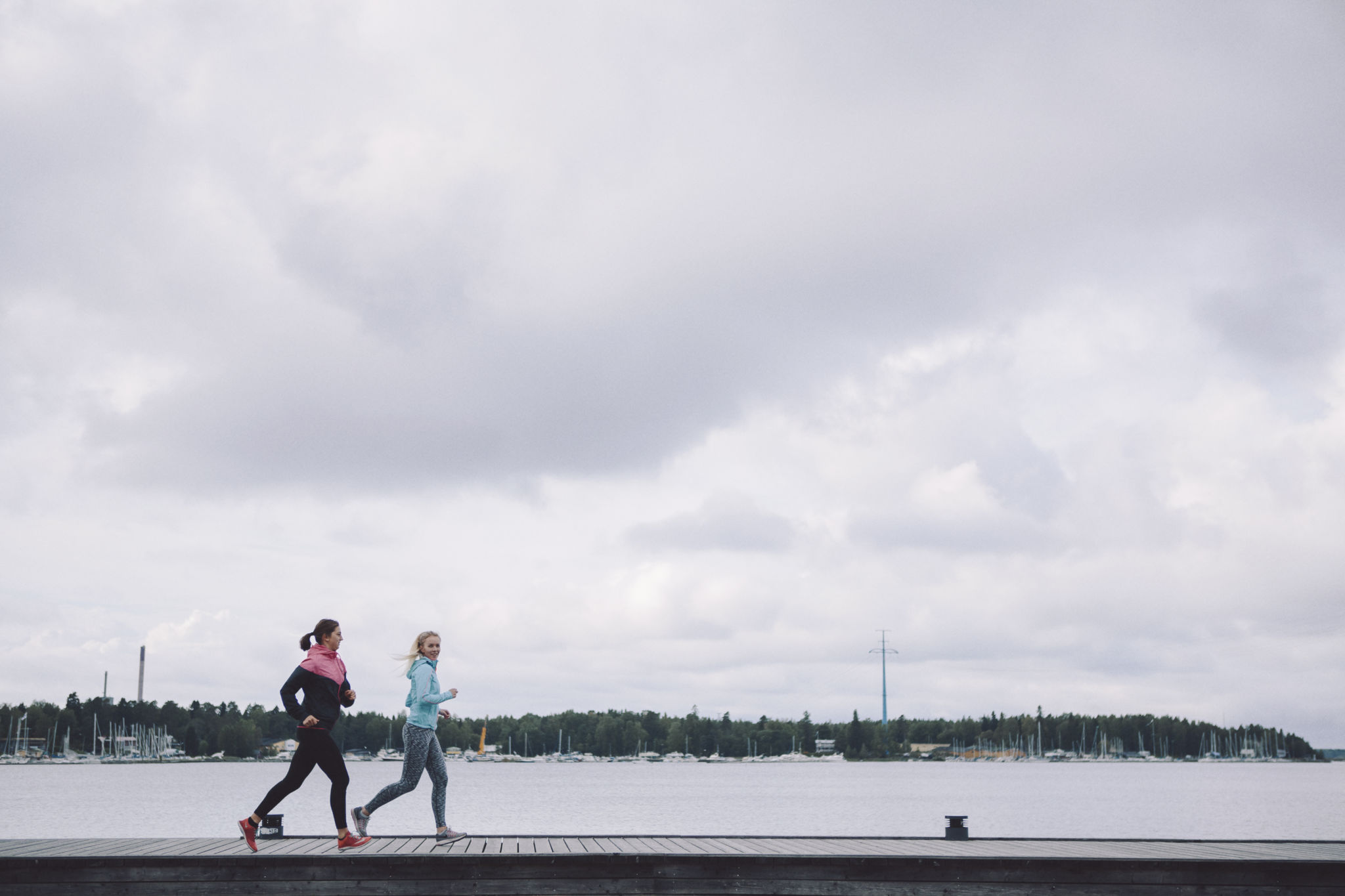Två joggare som springer längs med stranden.