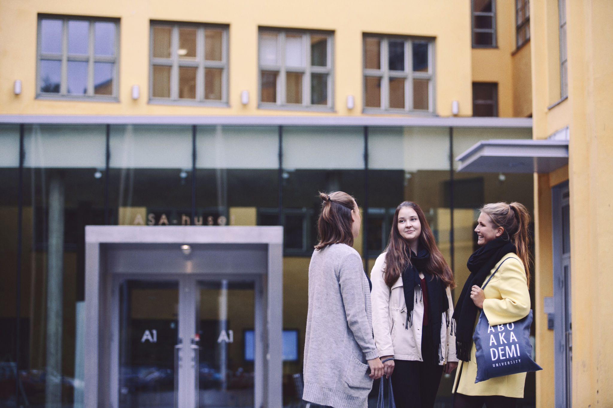 Tre studerande som står framför ASA byggnaden