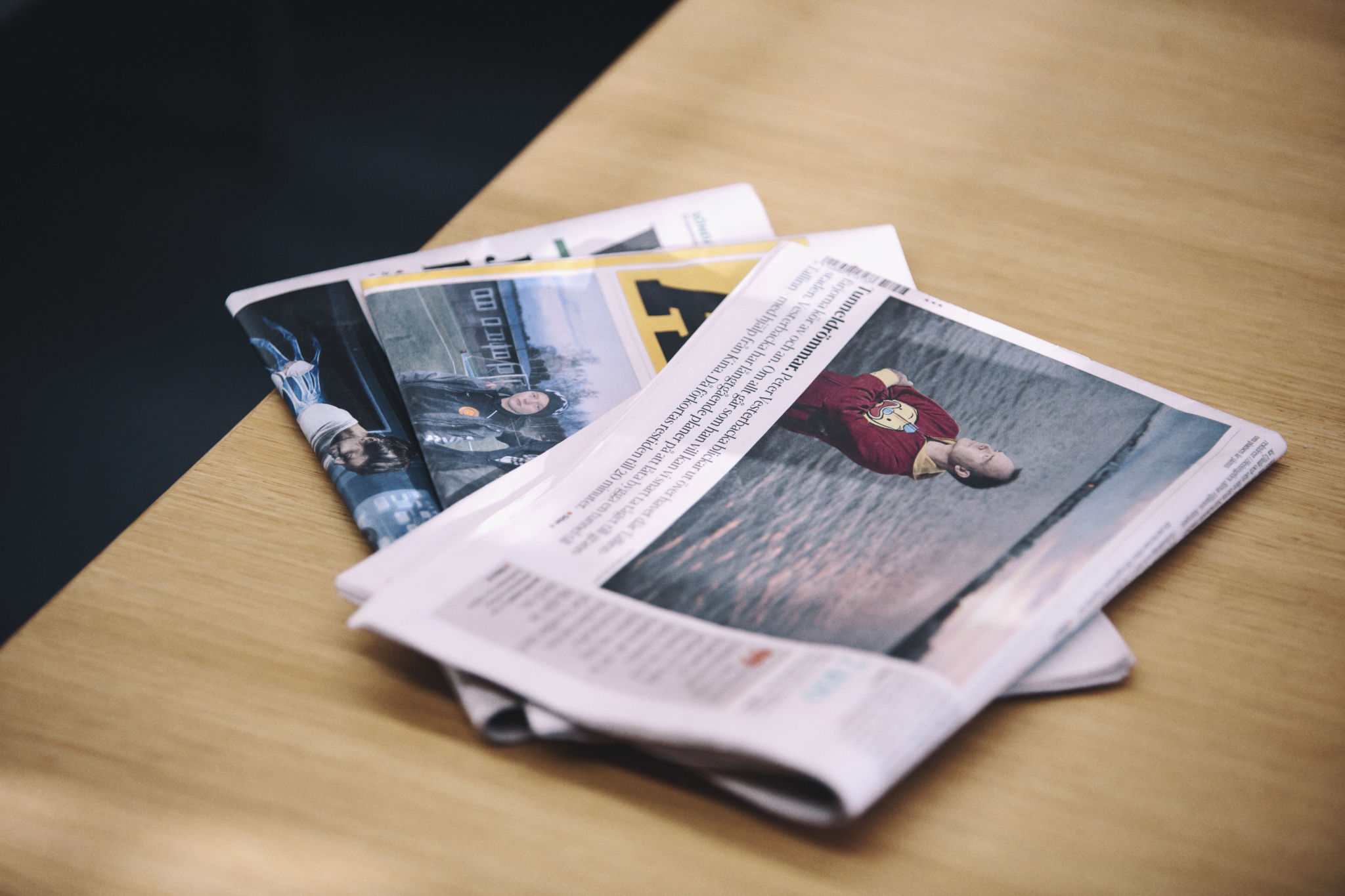 Tre dagstidningar på ett bord.