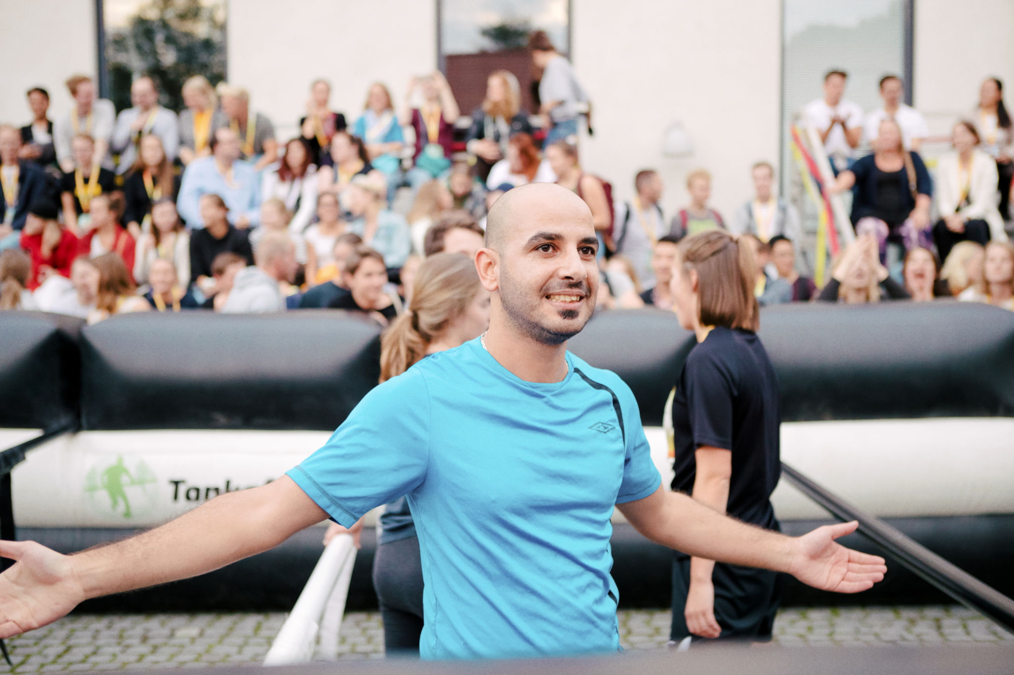 En man med utsträckta händer framför publik. A man with open arms in front of an audience.
