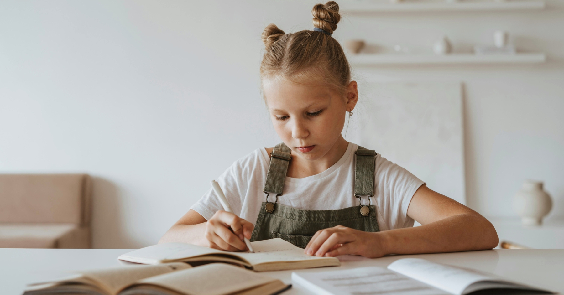 Foto av en flicka som skriver i en bok.