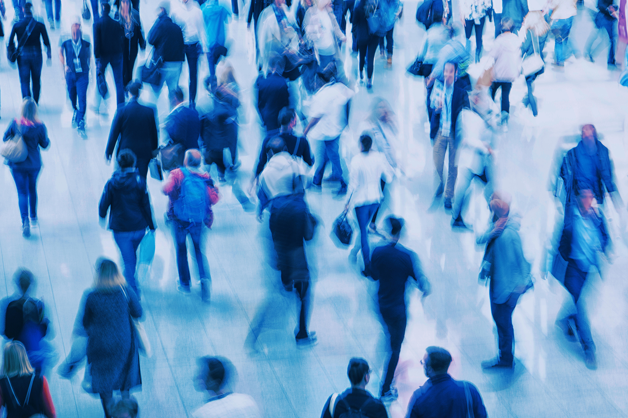 En folkmassa med många suddiga människor som rör sig.