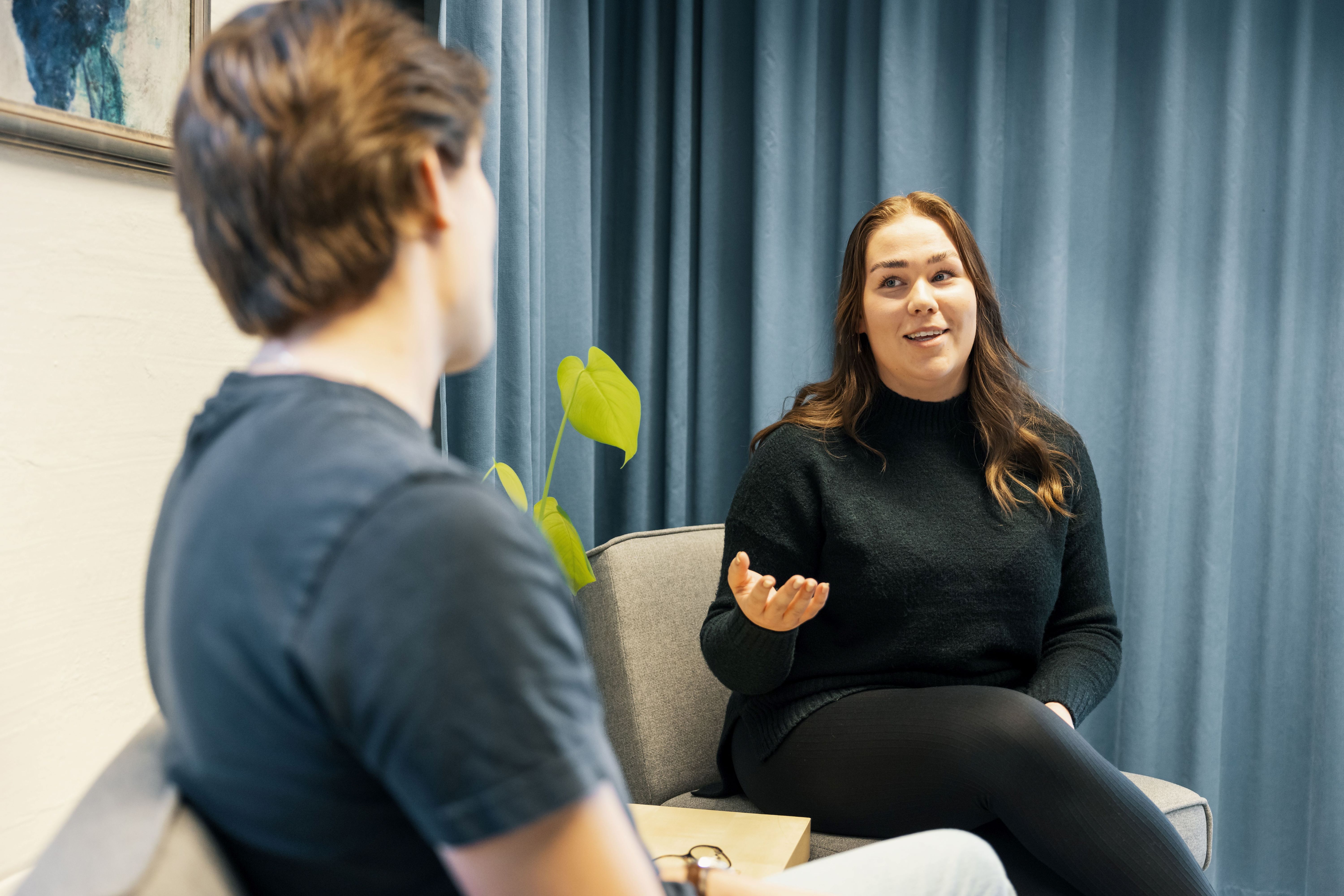 Två personer som sitter och samtalar.